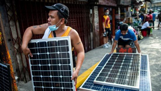 Men carrying solar panels