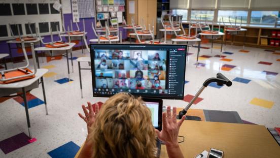 An elementary school teacher in Iowa, US, engaging with students in an online lesson.